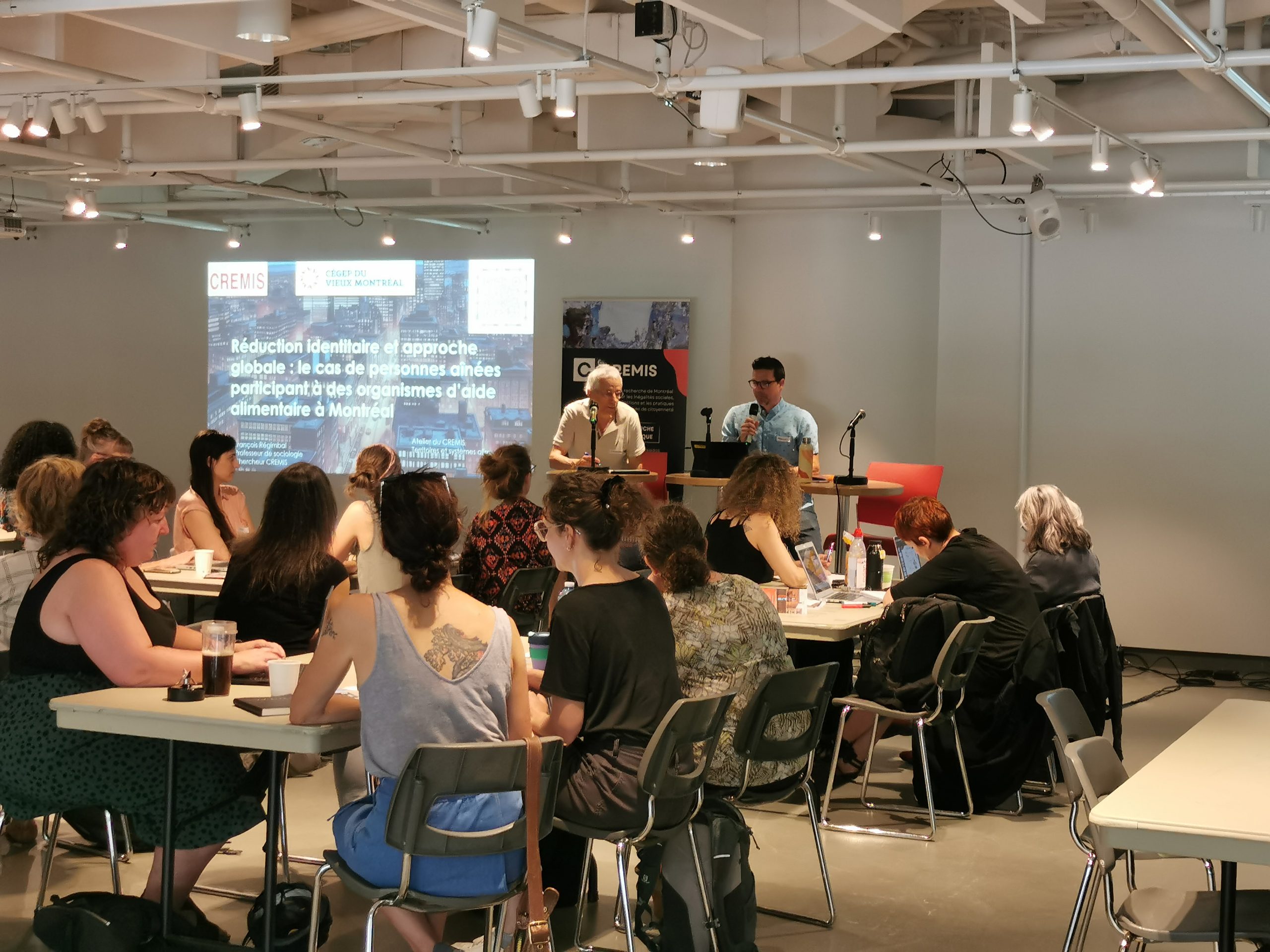 À l'agora du Cégep du Vieux-Montréal, lors de la première journée de l'événement sur les territoires et systèmes alimentaires. Vue des participant·e·s de dos.